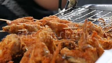泰国的街头美食.. 在面糊里炸鸡块。 街上的卖家正在卖一道异国风味的菜.. 买方